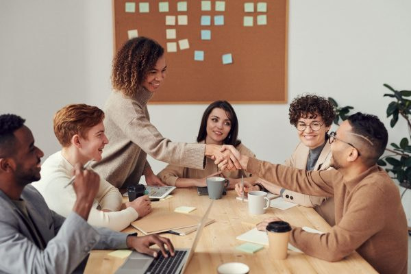woman shaking hands at meeting woman shaking hands at presentation