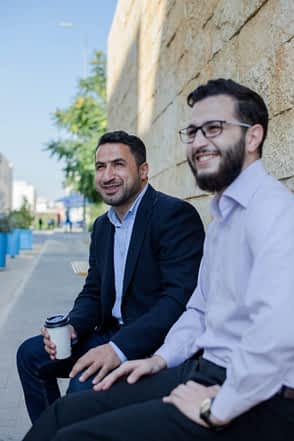 two_men_in_suits_sitting_outside_and_having_a_business_meeting-scopio-35c05921-f723-4556-9962-e4056ac21efc-min two business men