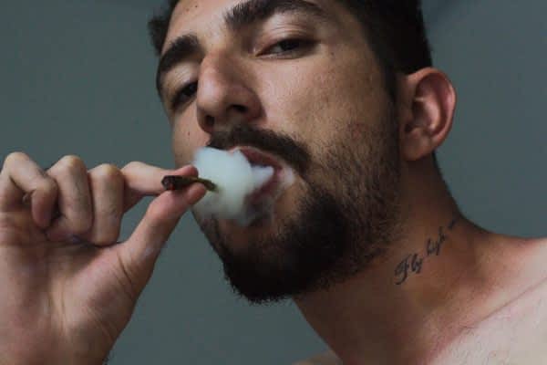 man-smoking-tobacco-inside-room-1998456-min man smoking