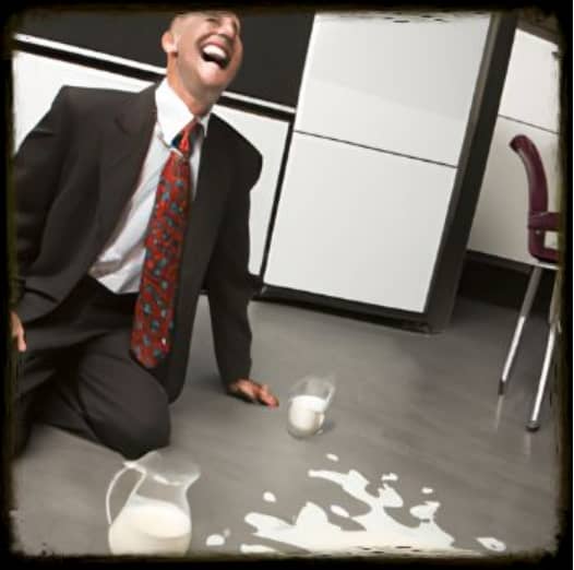 business man laughs at spilled milk